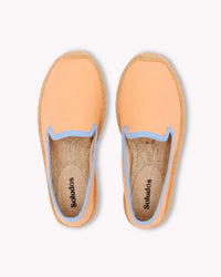 Overhead image of peach colored kids smoking slipper espadrille with light blue piping trim