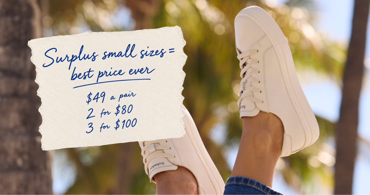 Off-white Soludos platform sneakers worn with blue jeans outdoors, featuring a small-size sale: $49 a pair, 2 for $80, or 3 for $100.