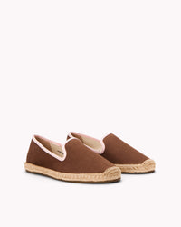 Women's brown espadrille shoes with light pink piping on gray background