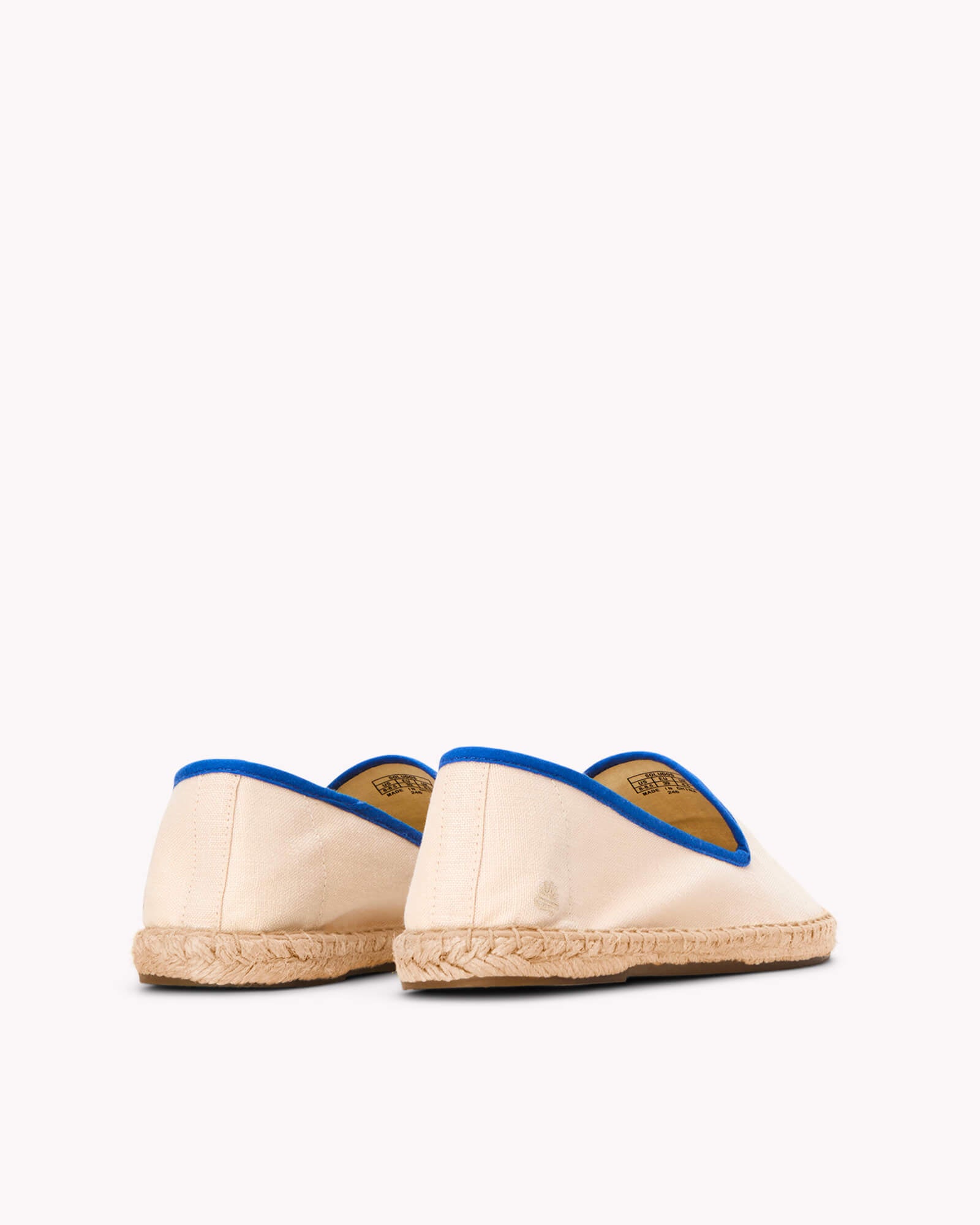 Women's ivory espadrille shoes with blue piping on gray background